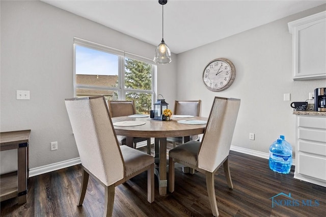 dining room featuring baseboards and dark wood-type flooring