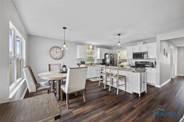 dining room with dark wood-type flooring and baseboards