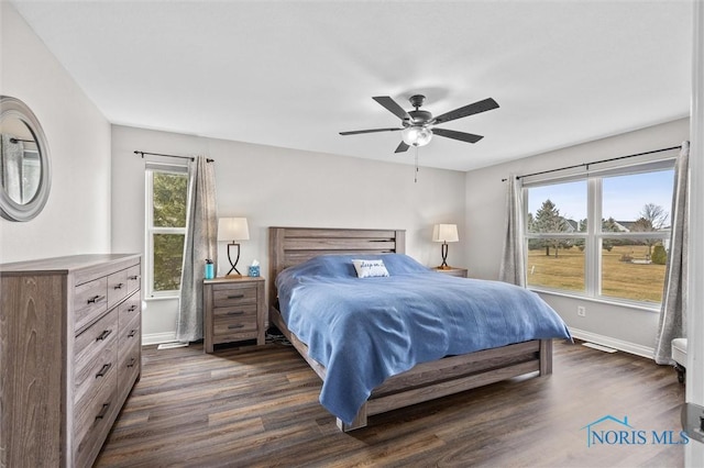 bedroom featuring ceiling fan, dark wood-style flooring, and baseboards