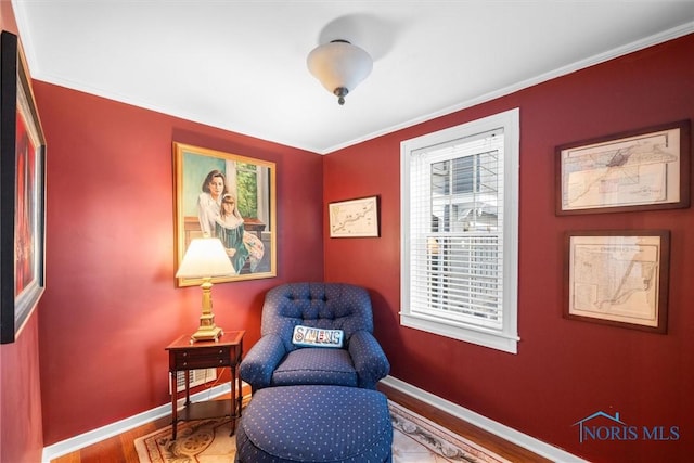 sitting room with crown molding, baseboards, and wood finished floors