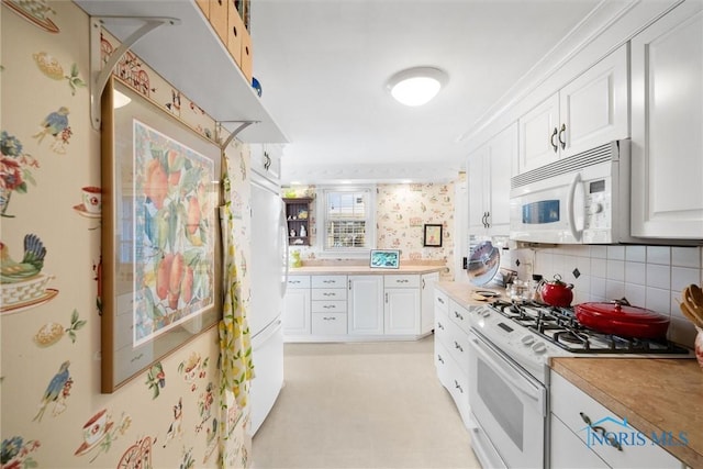 kitchen featuring white appliances, light countertops, decorative backsplash, and white cabinets