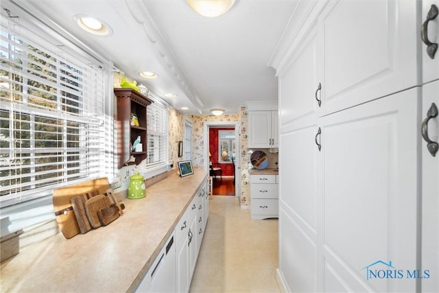 kitchen featuring light countertops, recessed lighting, white cabinetry, and wallpapered walls