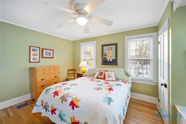 bedroom with visible vents, light wood-style flooring, baseboards, and multiple windows