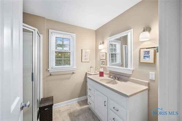 full bathroom with vanity, baseboards, and an enclosed shower