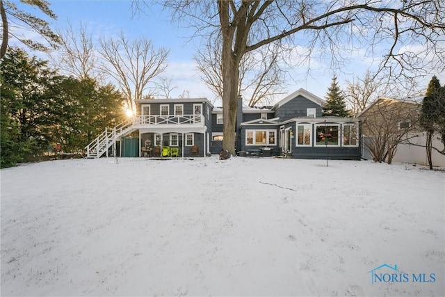 snow covered house featuring stairs