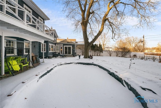 yard layered in snow with fence