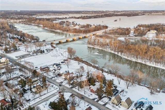 snowy aerial view featuring a water view