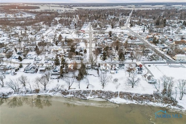 snowy aerial view with a water view and a residential view