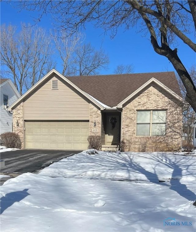 ranch-style house with a garage, a shingled roof, aphalt driveway, and brick siding