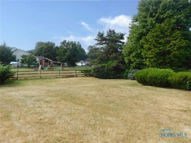 view of yard featuring fence and a playground