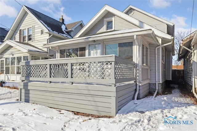 view of snow covered exterior featuring a sunroom