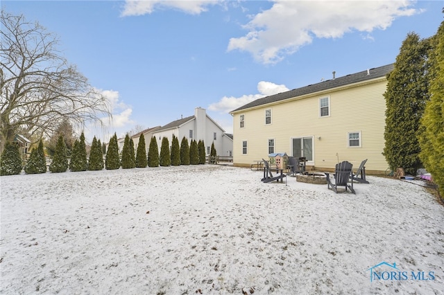 back of house with a fire pit