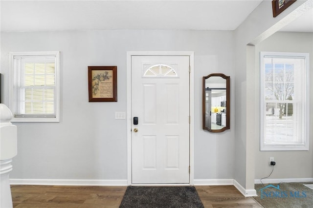 foyer with dark wood finished floors and baseboards