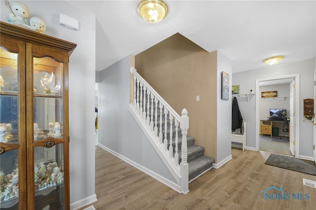 staircase with baseboards and wood finished floors