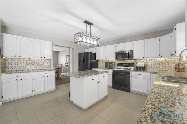 kitchen featuring a sink, black fridge with ice dispenser, light stone countertops, stainless steel microwave, and range with gas cooktop