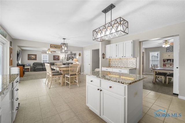 kitchen featuring pendant lighting, white cabinets, light tile patterned flooring, and decorative backsplash