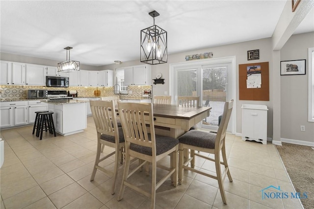 dining area featuring light tile patterned floors and baseboards