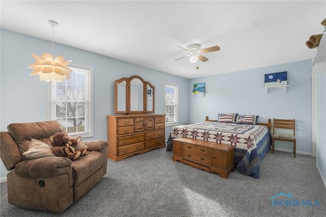 carpeted bedroom featuring ceiling fan and baseboards