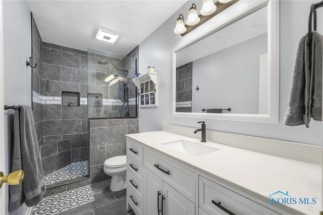 full bath featuring a walk in shower, toilet, tile patterned flooring, and vanity