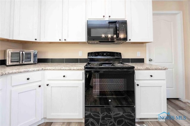 20391 Brown Ln, Weston, OH 43569 - kitchen with black appliances, light wood-style flooring, light countertops, and white cabinetry