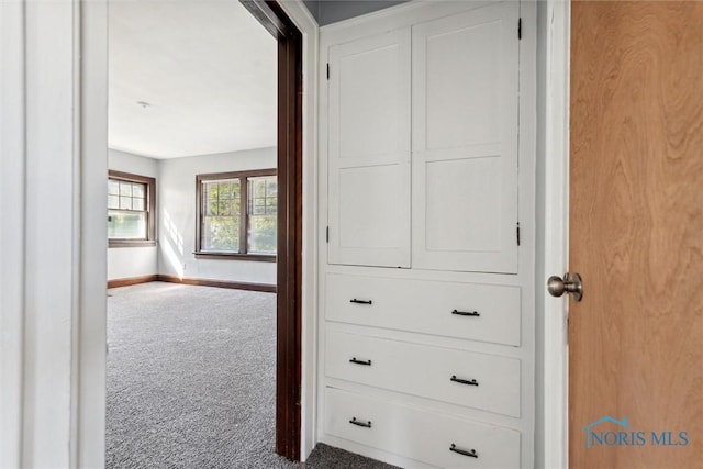 hall featuring carpet floors and baseboards