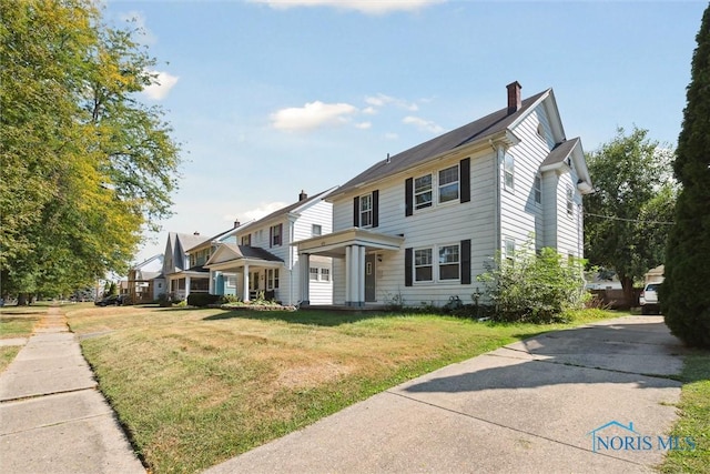 view of front of home featuring a front lawn and a chimney