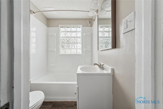 full bathroom with  shower combination, vanity, toilet, and a textured ceiling