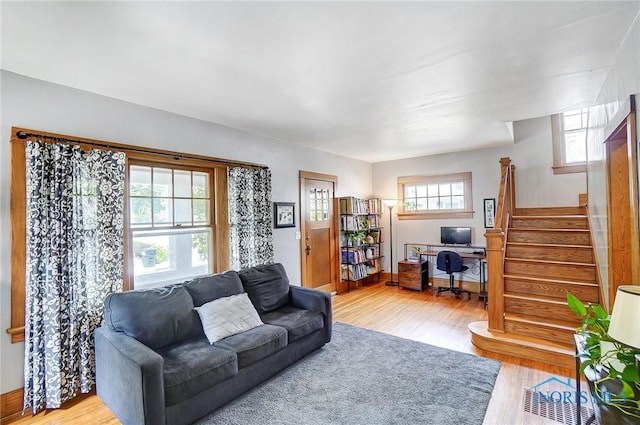 living area with stairway and wood finished floors