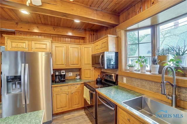 kitchen with stainless steel appliances, a sink, wood ceiling, beam ceiling, and dark countertops