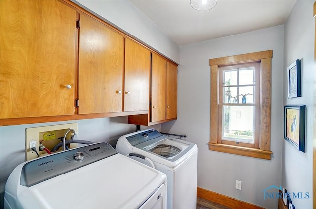 washroom featuring cabinet space, washing machine and dryer, and baseboards