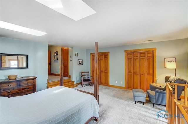 bedroom featuring a skylight, baseboards, visible vents, light colored carpet, and a closet