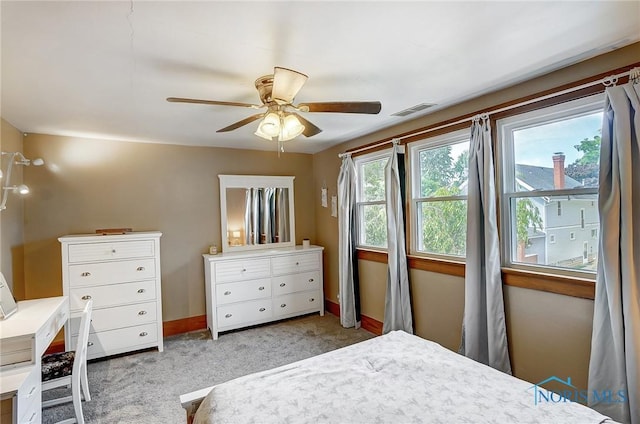 bedroom featuring baseboards, visible vents, a ceiling fan, and light colored carpet