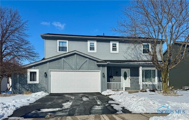 view of front of home with aphalt driveway, covered porch, and stucco siding