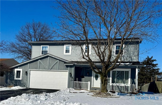 view of front of house with a garage, covered porch, driveway, and stucco siding