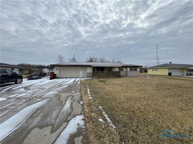 ranch-style home with a garage, driveway, a front lawn, and a porch