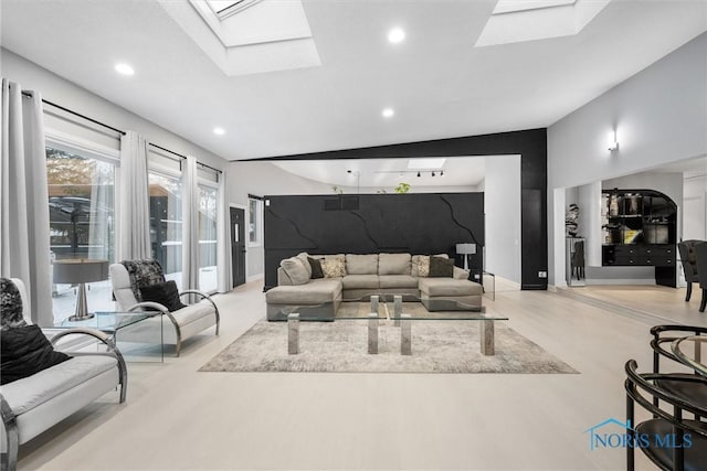 living room with baseboards, a skylight, light wood-style flooring, and recessed lighting