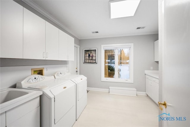 washroom featuring crown molding, cabinet space, visible vents, separate washer and dryer, and baseboards