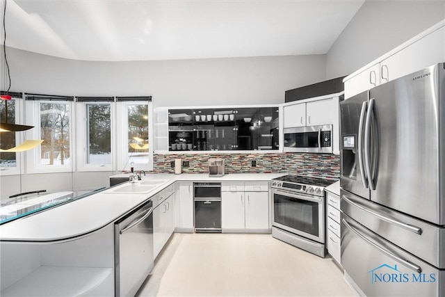 kitchen featuring appliances with stainless steel finishes, light countertops, white cabinetry, and a sink