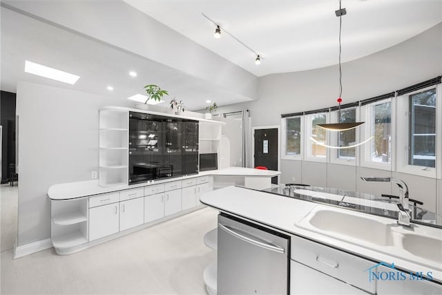 kitchen featuring light countertops, stainless steel dishwasher, decorative light fixtures, and white cabinets