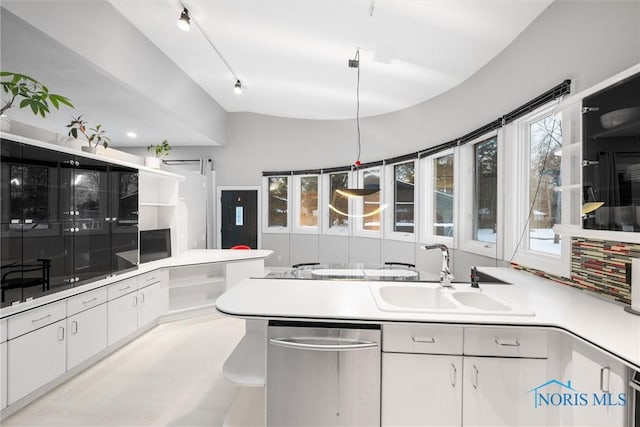 kitchen with a wealth of natural light, light countertops, white cabinetry, and hanging light fixtures