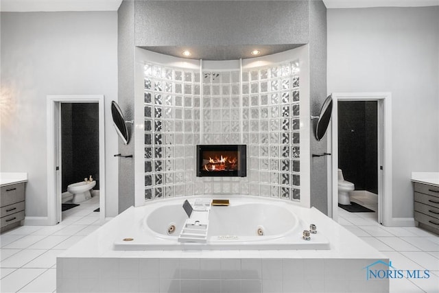 bathroom featuring toilet, a bidet, tile patterned flooring, and vanity