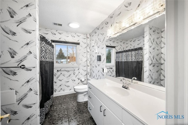 bathroom with a stall shower, wallpapered walls, visible vents, toilet, and vanity