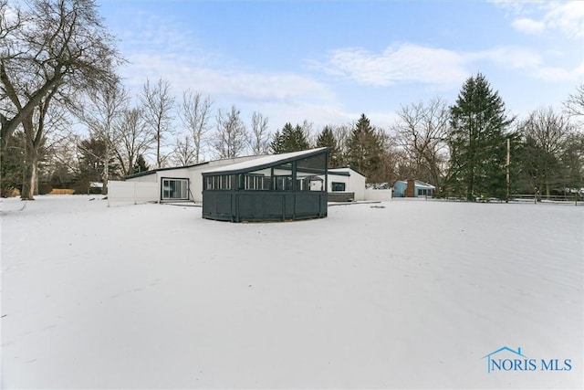 view of snow covered back of property