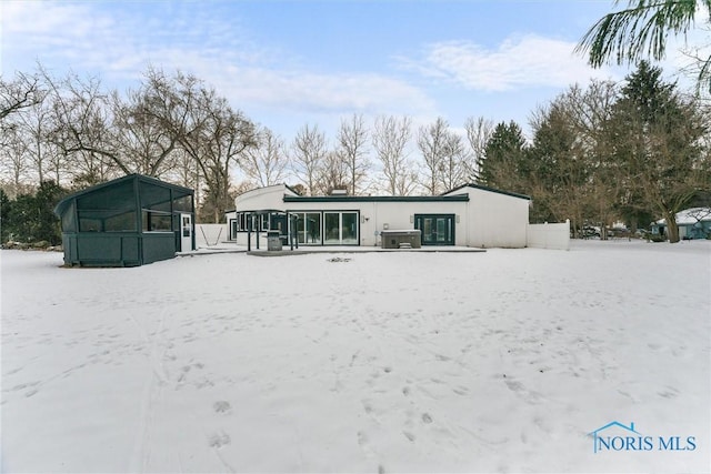 snow covered back of property featuring central air condition unit