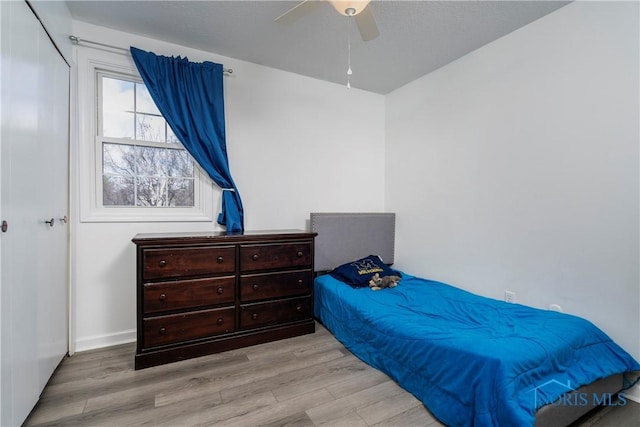 bedroom with a ceiling fan and light wood-style flooring