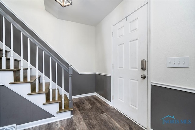 foyer entrance with stairs, baseboards, and dark wood finished floors