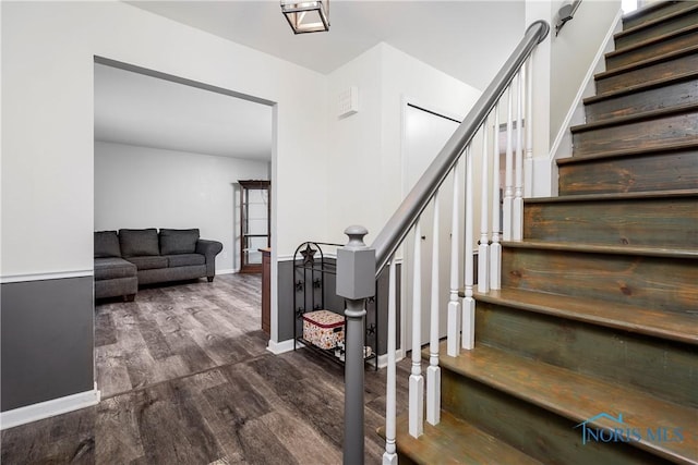 stairway with baseboards and wood finished floors