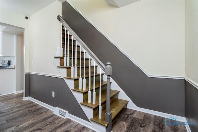 stairs with visible vents, baseboards, and wood finished floors