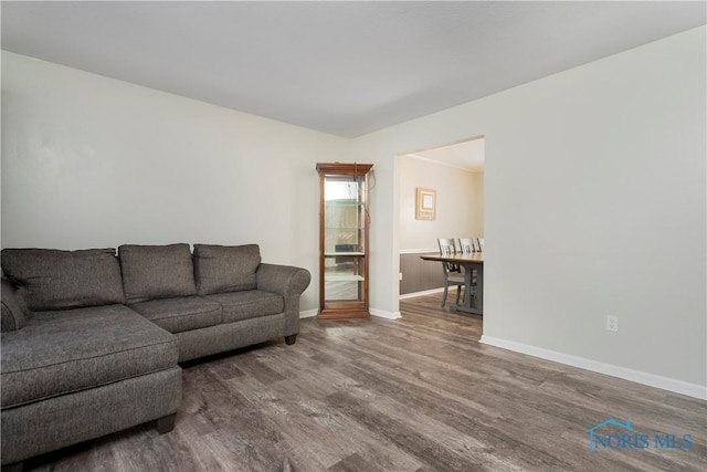 living area with baseboards and wood finished floors