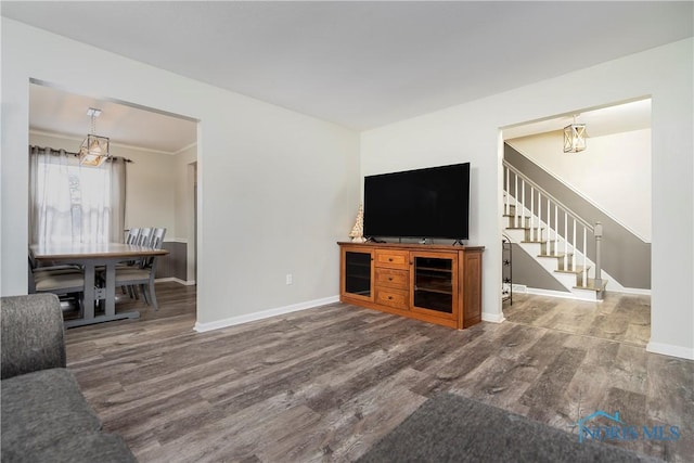 living area with stairs, wood finished floors, and baseboards